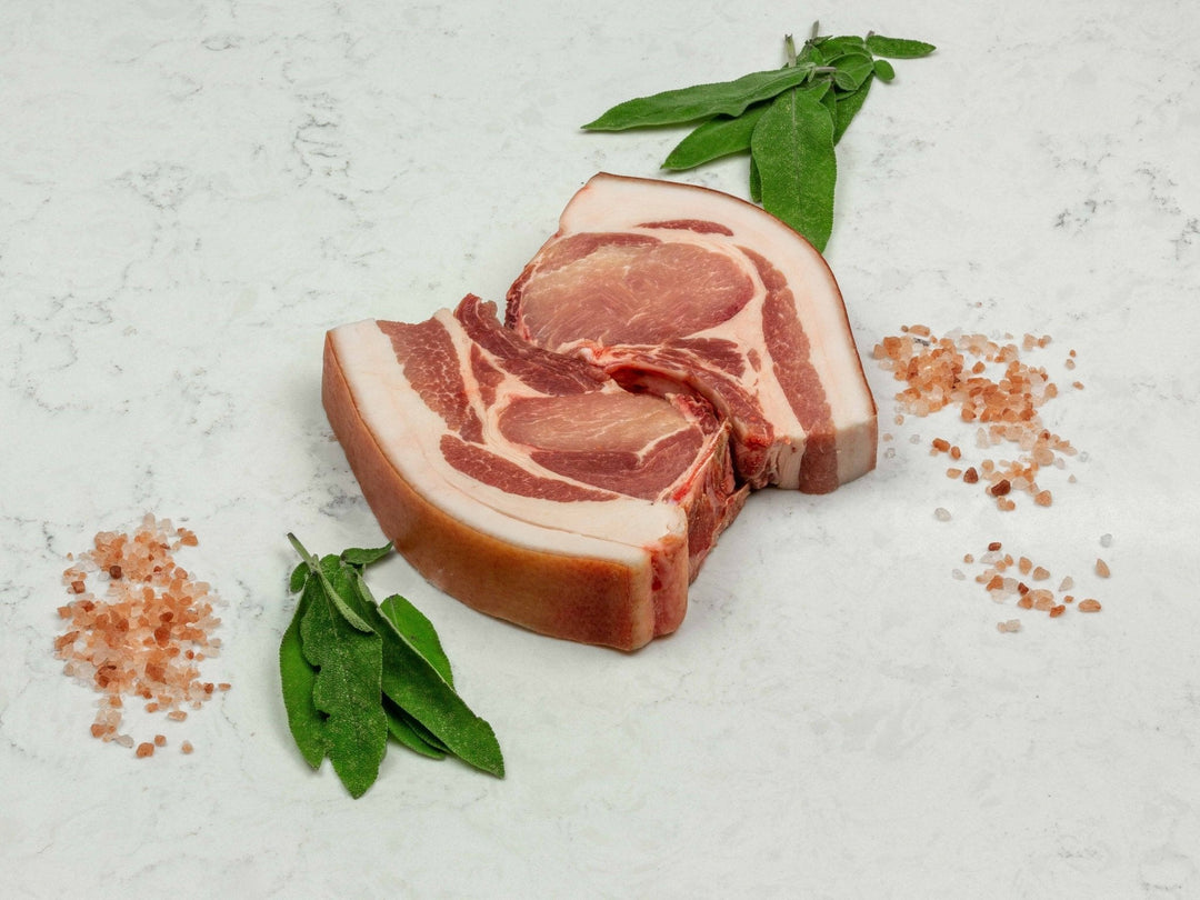 Free-range dry-aged pork chop with a thick fat cap